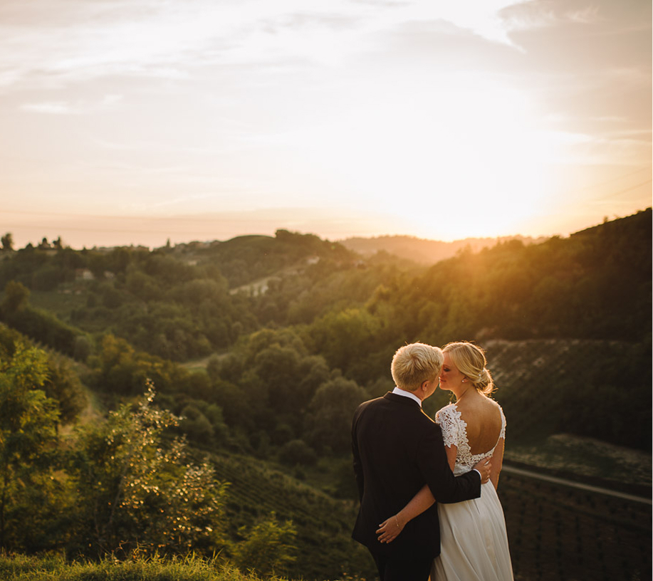 Newlyweds embracing at sunset above the vineyard hills
