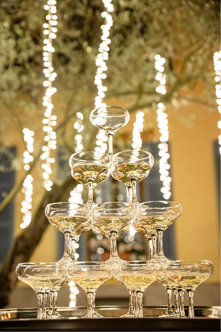 Champagne tower glowing under warm string lights
